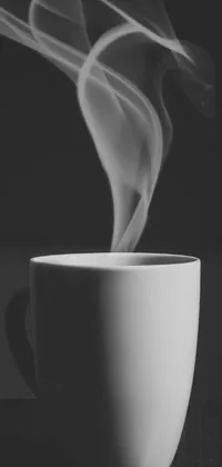 This live wallpaper showcases a white cup and wooden table, with a monochromatic photo floating in smoke