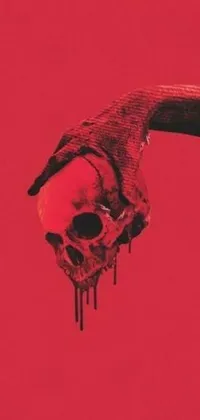Transform your phone screen with a strikingly beautiful and haunting live wallpaper featuring a bloody hand holding a skull on a deep red background