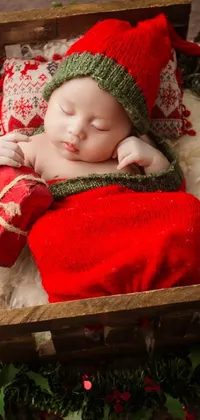 This phone live wallpaper features an adorable baby sleeping in a classic wooden box adorned with charming Christmas decorations