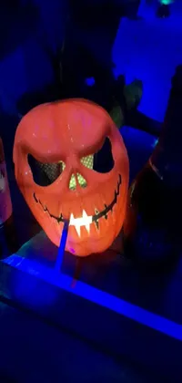 Get into the Halloween spirit with this animated live wallpaper featuring a lighted pumpkin on a table