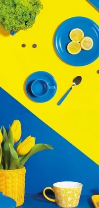 This phone live wallpaper showcases a colorful still life of blue and yellow plates and cups on a tabletop
