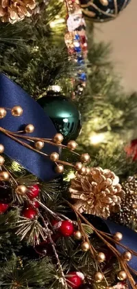 Bring the festive celebration to your phone with this stunning close-up view of a Christmas tree, adorned with vibrant ornaments in magnificent Prussian blue and Venetian red