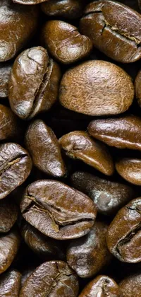 This phone live wallpaper showcases a close-up of roasted coffee beans that exude warmth and rich brown hues, set against a deep black background