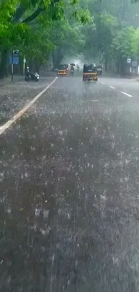 Looking for a captivating live wallpaper for your phone? Look no further than this rainy street scene! The wallpaper features a car driving down the road in the rain, with droplets falling on the windshield