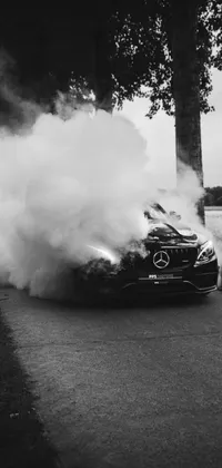 This live phone wallpaper features a black and white photo of a vintage Mercedes-Benz car with smoke emanating from it