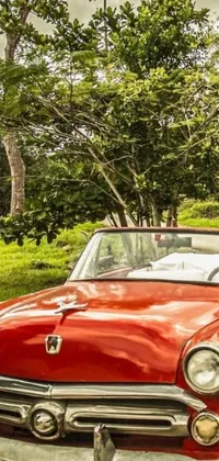 This is a mesmerizing live wallpaper for your phone featuring an old red car parked on a beautiful road in Jamaica
