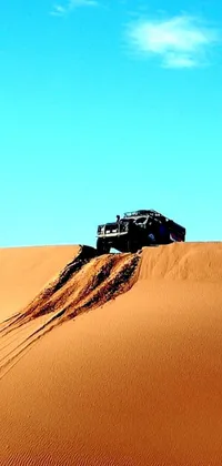 This live wallpaper for your phone features a tough truck parked in desert sand, gazing out at an enormous, leaping horizontal mesa