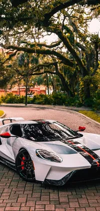 This live wallpaper showcases a beautiful white sports car parked on a brick road