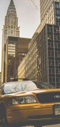 This mobile wallpaper depicts a parked yellow taxi cab in front of a tall urban building