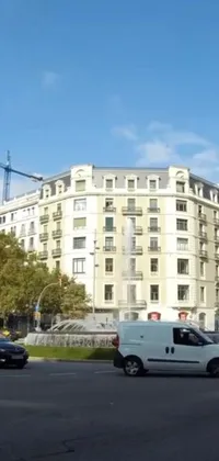 This live wallpaper showcases a white van driving through a busy Barcelona street alongside a towering neoclassical building