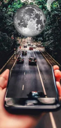 This phone live wallpaper features a highly realistic depiction of a person holding a cell phone amid a bustling cityscape