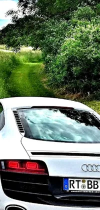 This live phone wallpaper depicts a beautiful white sports car parked on the side of a country road