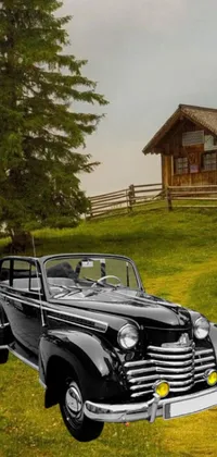 This vintage car live wallpaper features a classic model parked in front of a wooden cabin on a hill amidst a serene mountain landscape