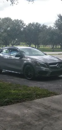 This live wallpaper showcases a gun metal grey car parked in a parking lot next to a tree