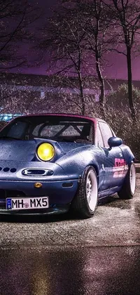 This blue sports car live wallpaper features a parked vehicle on a dusty road in a dirt track