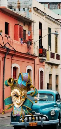 This live wallpaper features a car with a colorful mask driving down a street lined with colonial style buildings