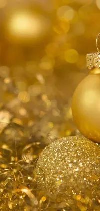 This beautiful live wallpaper depicts a close-up of a stunning golden Christmas ornament that captures every intricate detail of its design