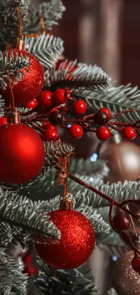 This phone live wallpaper offers an exquisite close-up of a beautiful Christmas tree, artistically decorated with colorful ornaments in various shades of red, brown, and grey to reflect the traditional Christmas color palette