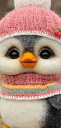 This phone live wallpaper presents a stuffed penguin in a pink hat and scarf