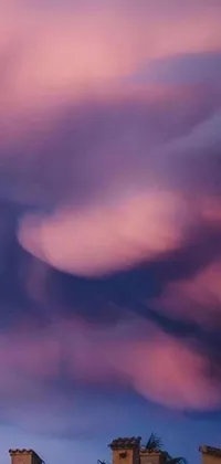 This live wallpaper features a beautiful digital art image of clouds in soft shades of purple and pink against a light-filled background
