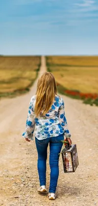 This phone live wallpaper shows a courageous young girl walking down a dusty road carrying a suitcase and a picture