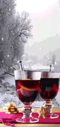 This winter-themed live wallpaper showcases two glasses of wine sitting on a wooden table surrounded by flickering candles and falling snowflakes