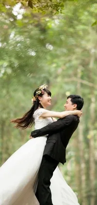 This romantic wallpaper showcases a man in a tux and a woman in a bridal gown in a serene forest
