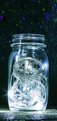 This phone live wallpaper features an elegant glass jar on a wooden table, with twinkling stars and glowing veins of white in the background