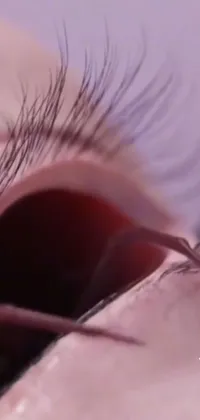 This phone live wallpaper showcases a dramatic close-up of an eye, with long, flickering lashes
