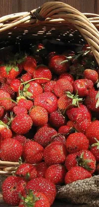 This live wallpaper showcases a basket full of strawberries on a wooden table