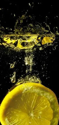 This Lemon Drop live wallpaper features a captivating underwater photograph of a lemon slice falling into water