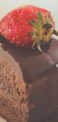 This live wallpaper depicts a closeup shot of a tempting chocolate cake topped with a bright red strawberry