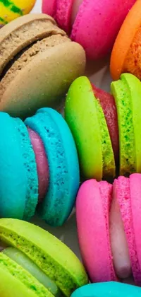 This live phone wallpaper showcases a vibrant and colorful pile of macarons arranged in a lovely color field