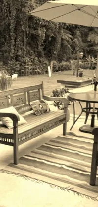 This phone live wallpaper features a black and white photograph of a tropical patio with wooden furniture, creating a clean and pristine design