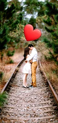 Bring your mobile to life with this stunning live wallpaper! Featuring a passionate kiss shared by a couple on a train track, the colorized photo perfectly captures the romance of the moment