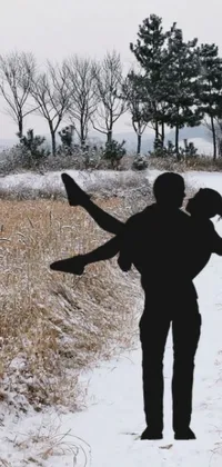 This phone live wallpaper depicts a couple walking through snowy terrain