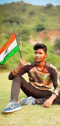 Are you looking for a stunning live phone wallpaper that embodies the pride and spirit of India? Look no further than this popular and trending image of a man holding an Indian flag on a clay background