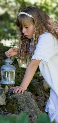 This live wallpaper features an adorable little girl in white holding a lantern, set in an enchanting forest background
