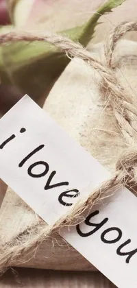 This phone live wallpaper features a love message on a plain paper tag