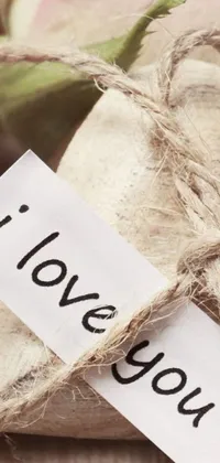 This live phone wallpaper depicts a piece of paper with the words "I love you" written on it in a touching, heartfelt message