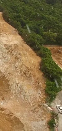 This live wallpaper showcases a stunning aerial view of a road surrounded by lush Malaysian jungle, with hints of construction sites and landslides