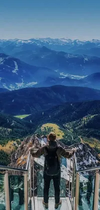 This phone live wallpaper showcases a stunning vista view from a glass walkway, with majestic mountains and serene blue skies in the background