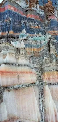 This phone live wallpaper features a stunning close-up of a rocky formation and mountain range in the background