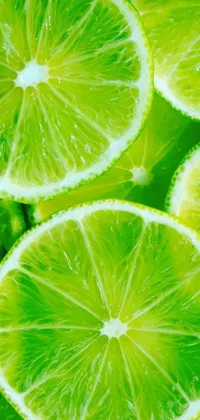 This captivating phone live wallpaper showcases the stunning close-up of limes with water droplets on them set against a vibrant green background