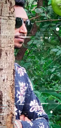 Get ready to add a new level of adventure and intrigue to your phone screen with this visually stunning live wallpaper! Featuring a man sporting cool sunglasses and set against a backdrop of lush and vibrant wild forest vegetation, this image evokes a sense of mystery and excitement
