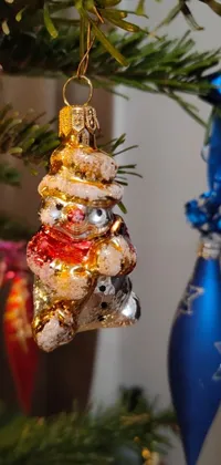 This Christmas live wallpaper features a festive ornament hanging from a tree adorned with silver, gold, and red details
