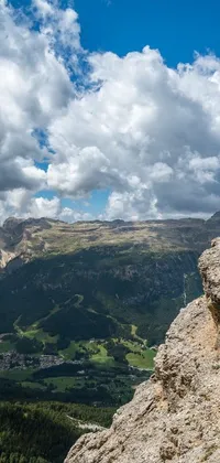 This live wallpaper depicts a man atop a mountain rock in the Dolomites
