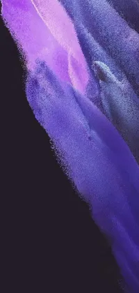This live phone wallpaper by Anna Füssli features a mesmerizing blue and purple brush stroke with sand particles on a black background