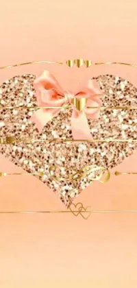 This stunning phone live wallpaper features a beautiful gold heart adorned with a pretty pink bow