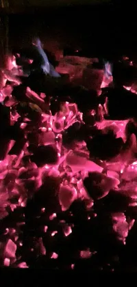 This phone live wallpaper features a high-contrast close-up of a fiery coal
